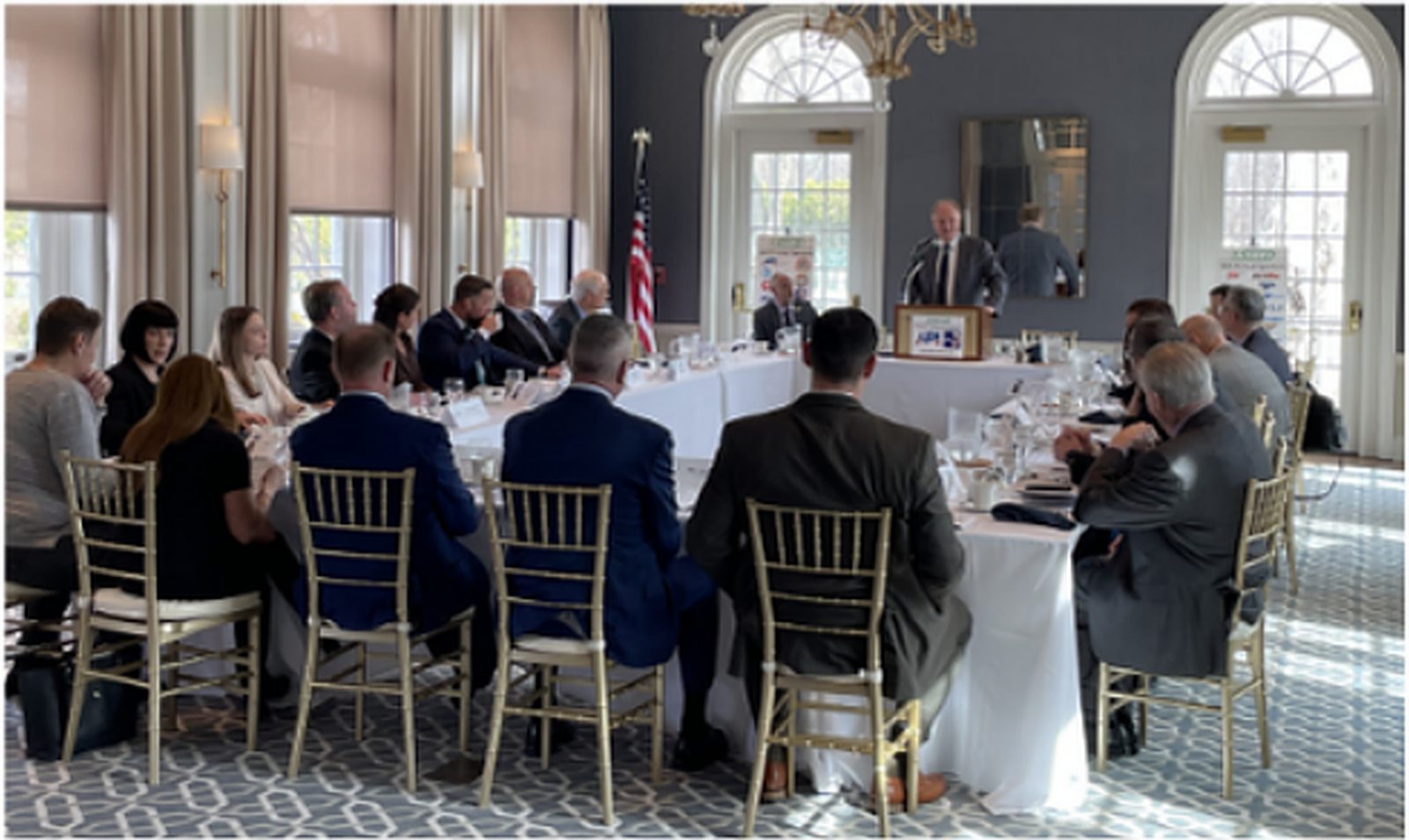 NJ SEED members seated at round tables listening to a speaker